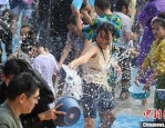 国庆假期第二天，众多游客齐聚西双版纳傣族园体验泼水节狂欢